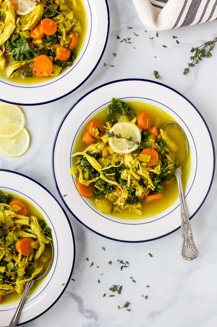 healing chicken soup recipe served in bowls topped with lemon