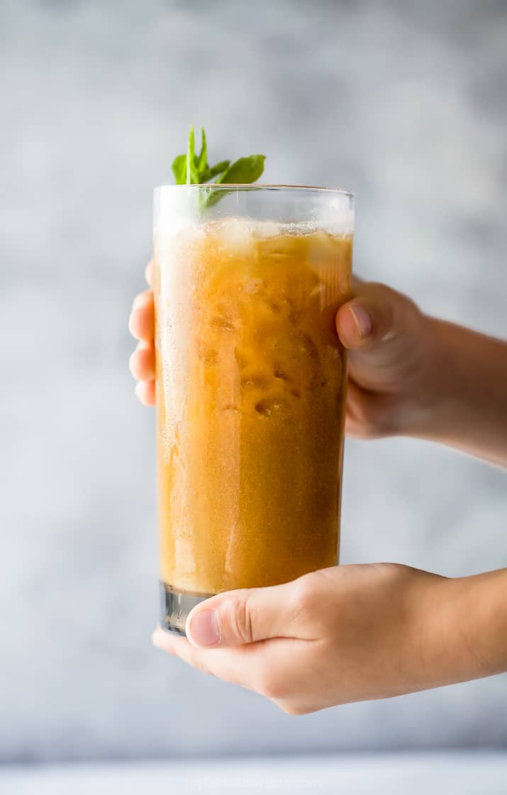 a hand holding a glass of easy coconut milk thai iced coffee