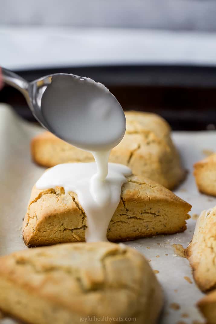 lemon glaze being poured on top of gluten free lemon poppy seed scones