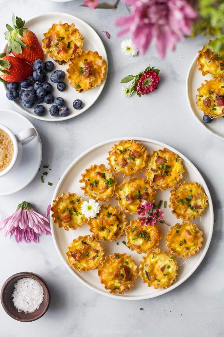 ham and cheese mini quiches topped with chives on a plate