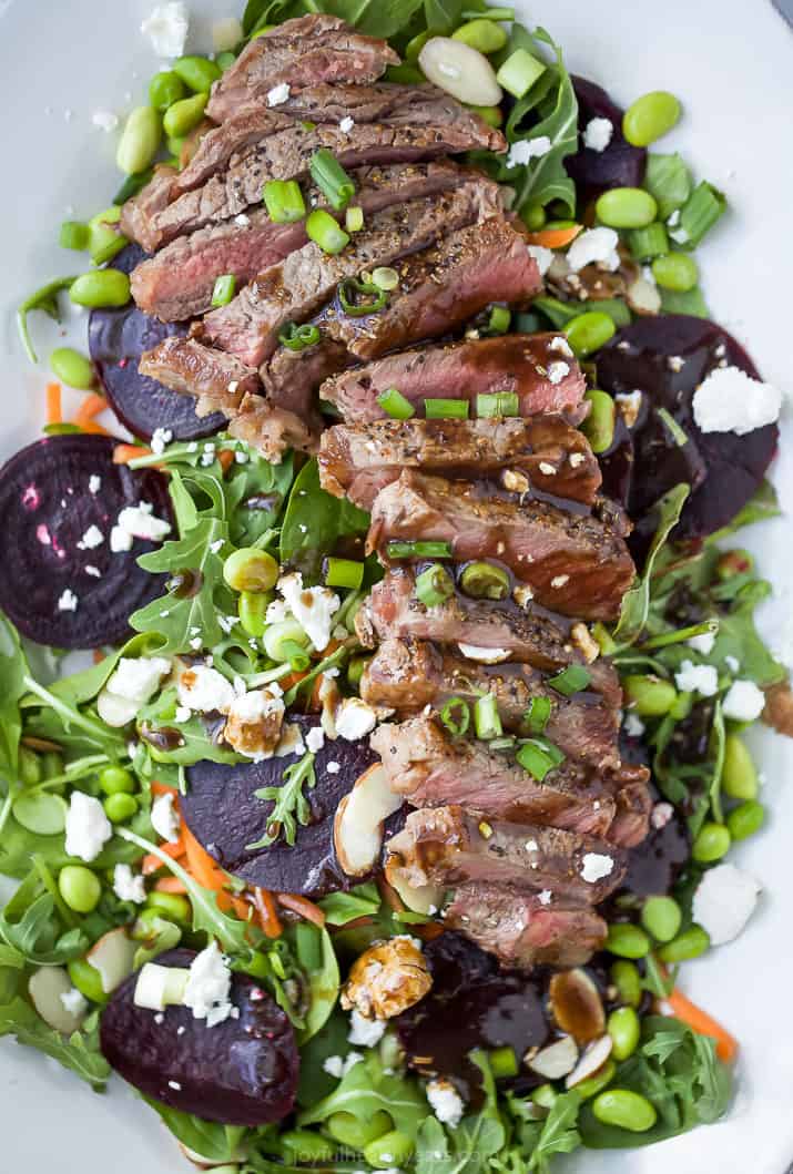 roasted beet steak salad on a large plate drizzled with balsamic dressing