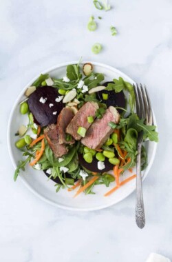 roasted beet steak salad with goat cheese and almonds on a plate