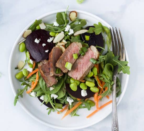 roasted beet steak salad with goat cheese and almonds on a plate