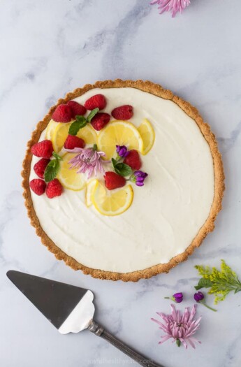 Creamy Lemon Tart Recipe with Almond Crust with flowers and berry on top