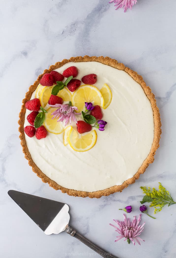 Creamy Lemon Tart Recipe with Almond Crust with flowers and berry on top