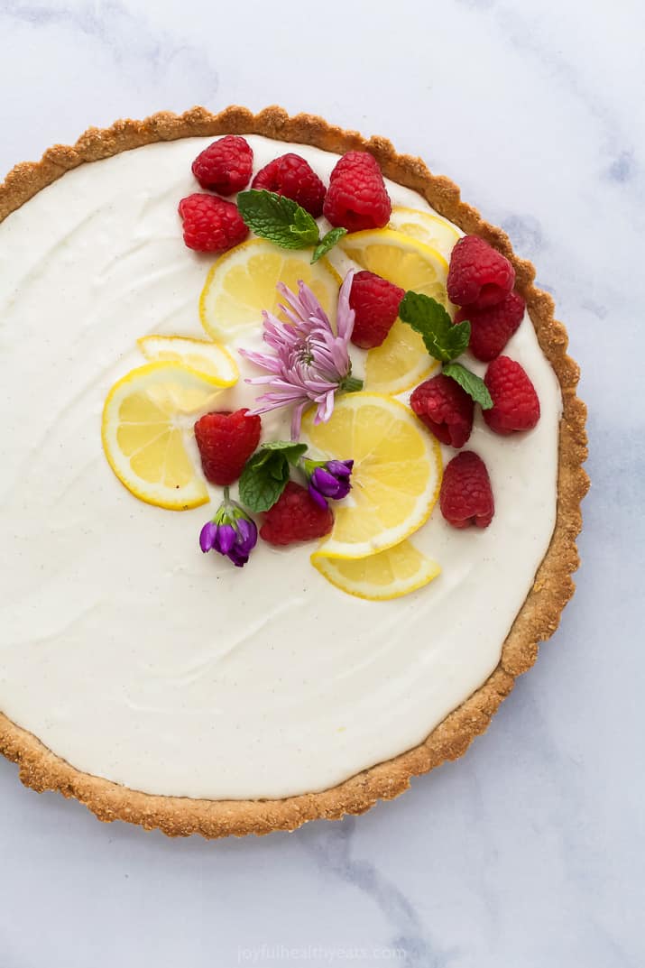 Creamy Lemon Tart Recipe with Almond Crust with flowers and berries on top