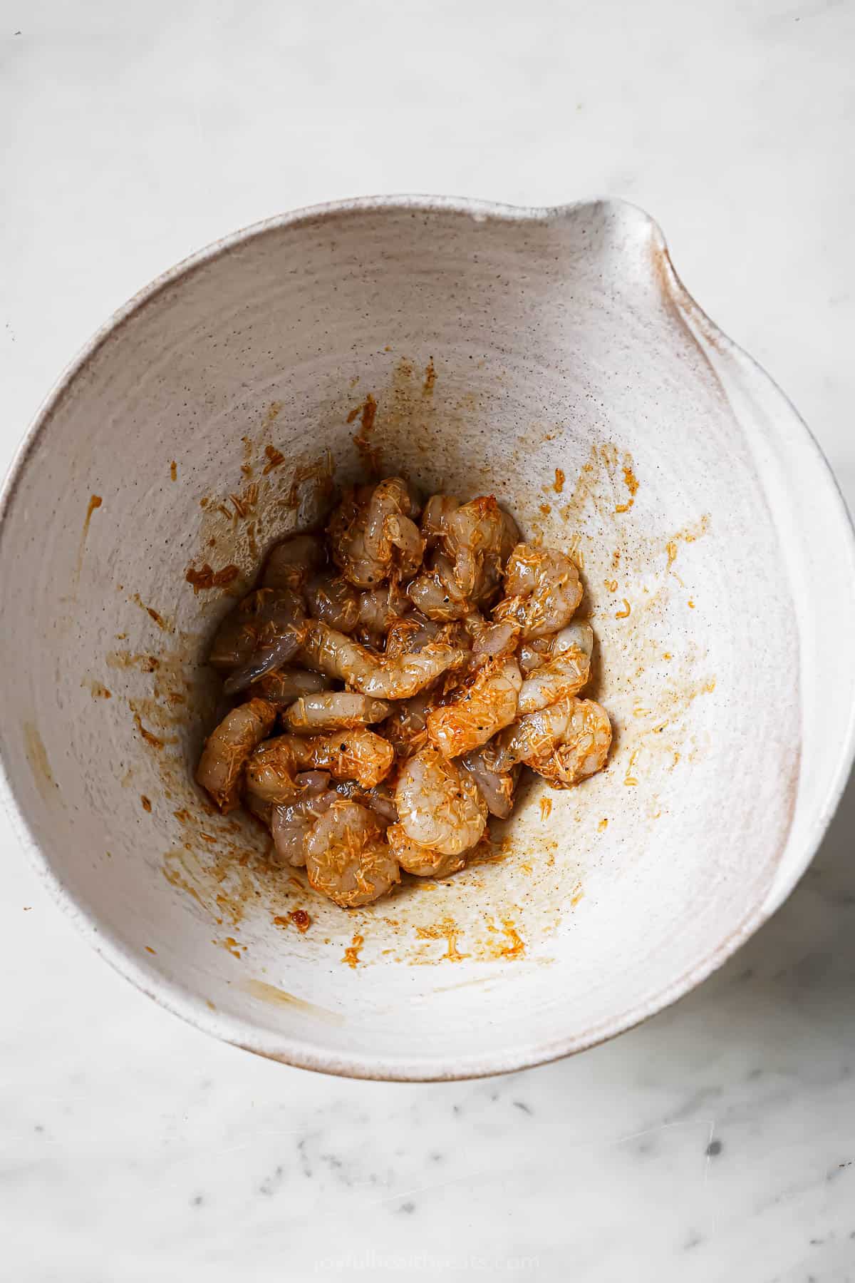 Tossing the shrimp with garlic-parmesan mixture. 