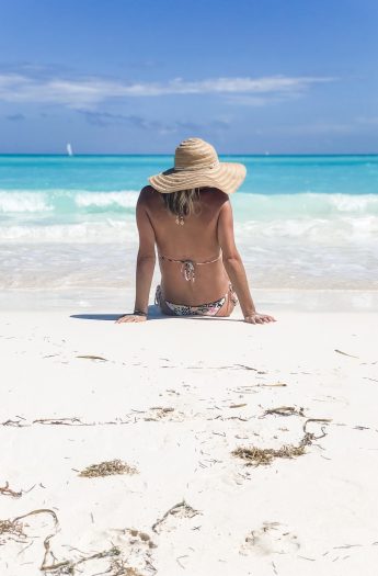 picture of a girl on a the beach with a hat