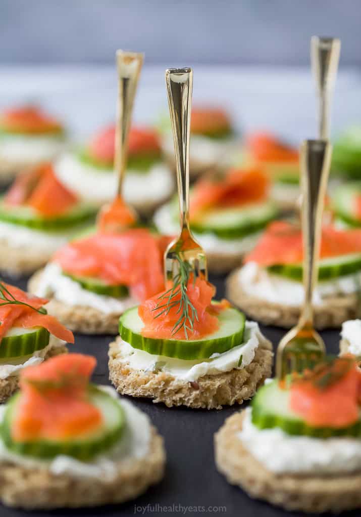 smoked salmon cucumber tea sandwiches on a serving tray with a small fork in them