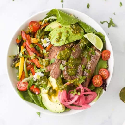 grilled fajita steak salad with chimichurri dressing in a bowl