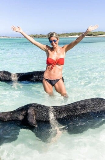 picture of a girl in the middle of swimming pigs