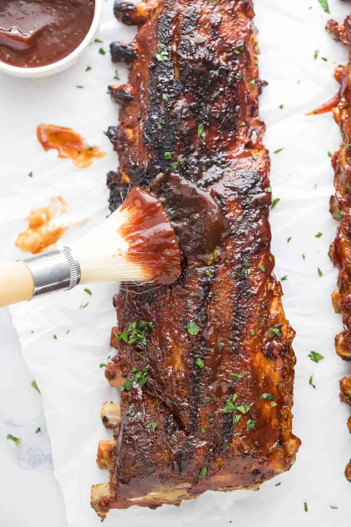 This fall-of-the-bone baby back rib recipe will be a favorite of July 4, with garlic-synamon spice rubs and BBQs Glass. Brush more BBQ sauce in the grilled rib.