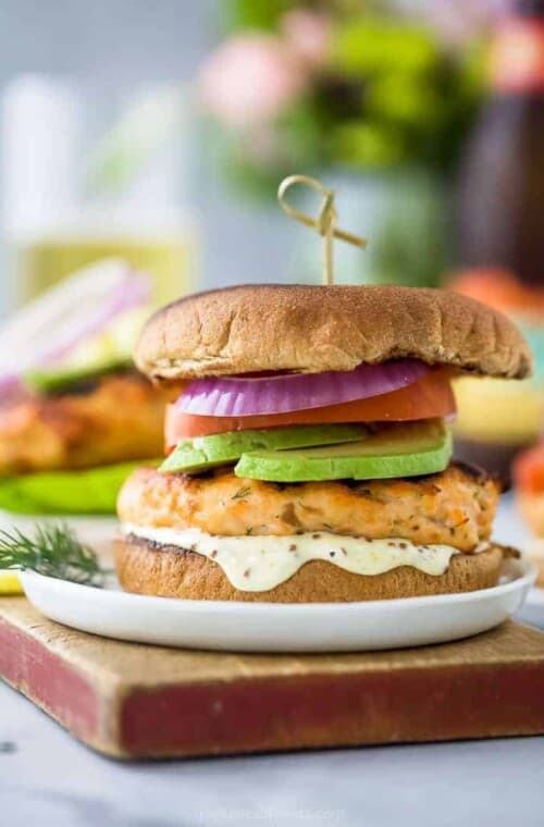 best grilled salmon burger topped with tomato, avocado, red onion and lemon garlic aioli