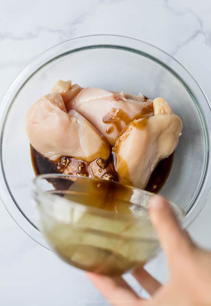 pouring balsamic marinade over chicken breast