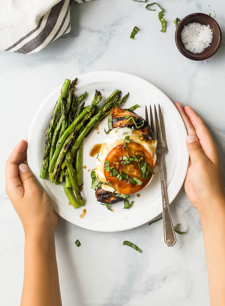 easy grilled balsamic caprese chicken on a plate with asparagus