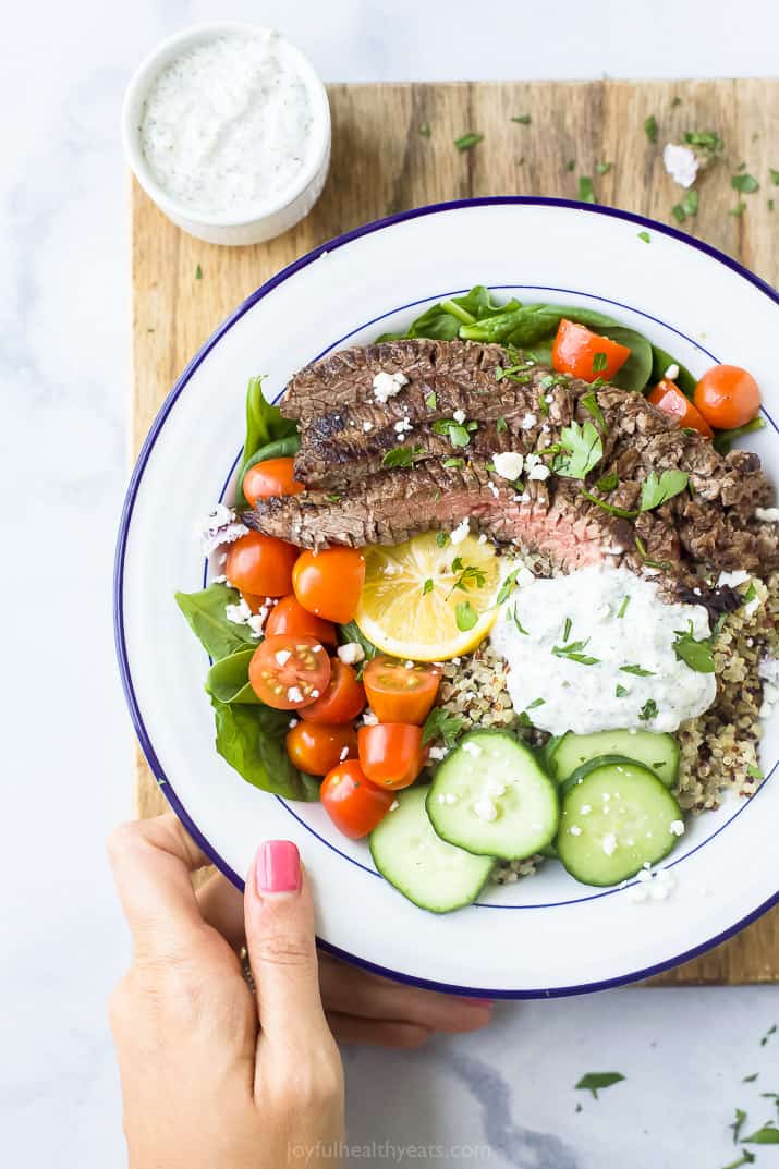 easy mediterranean steak and quinoa bowls with tzatziki on a cutting board 