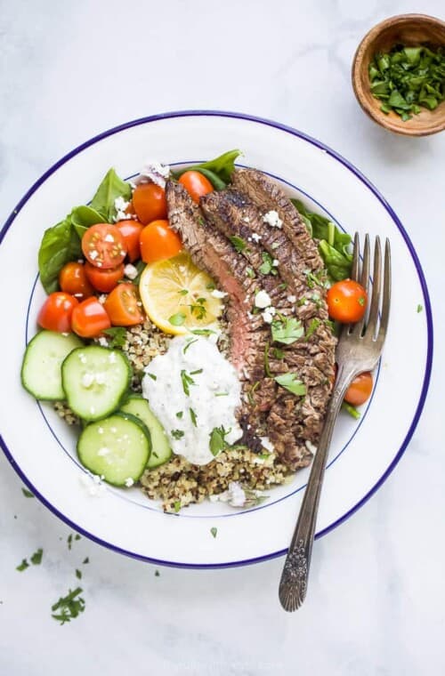 easy mediterranean steak and quinoa bowl topped with tzatziki