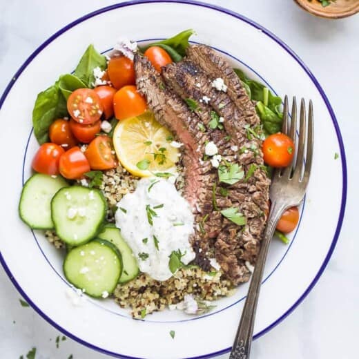 easy mediterranean steak and quinoa bowl topped with tzatziki