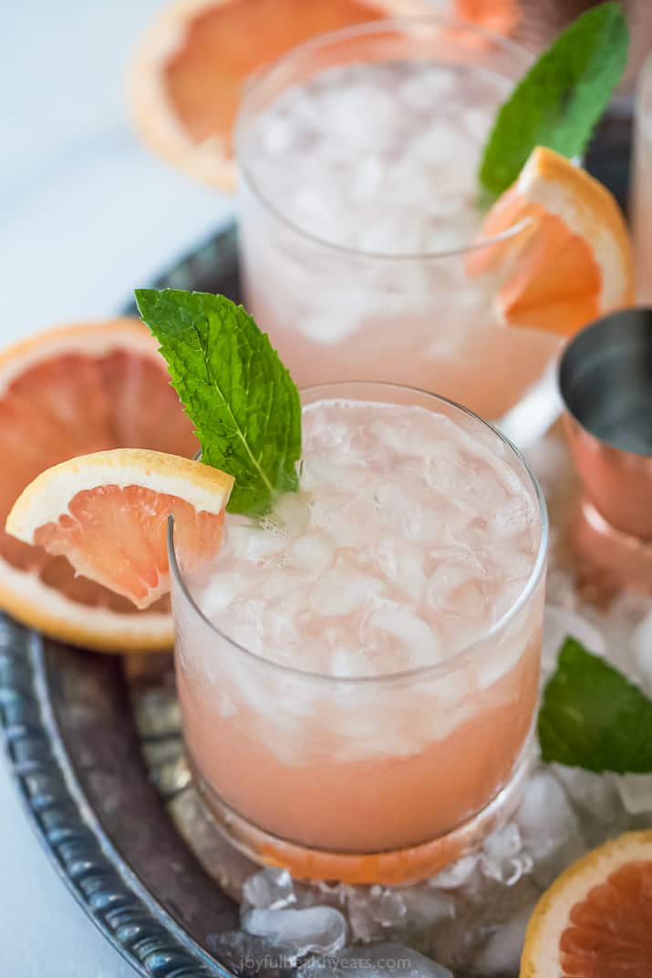 salty dog cocktail in two glasses garnished with mint and grapefruit slices