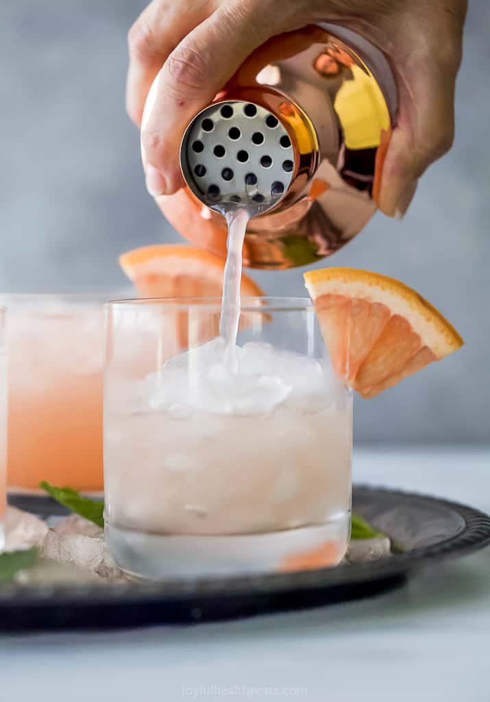 pouring homemade salty dog cocktail into a glass of ice