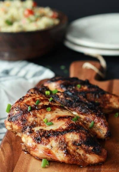 spice rubbed grilled chicken breast on a cutting board
