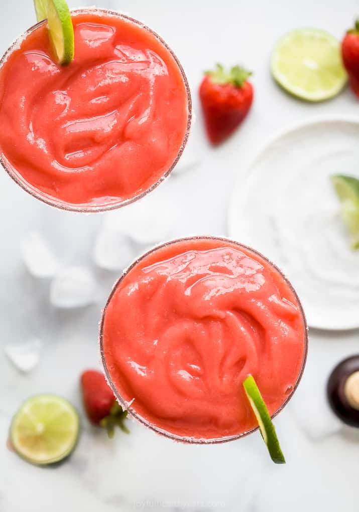 overhead photo of two glasses filled with frozen strawberry margaritas