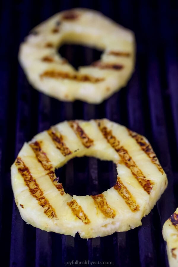 Juicy Grilled Pineapple is the easiest summer dessert and also the tastiest! Serve it as-is or fancy it up with a scoop of ice cream. Pineapple cooking on grill