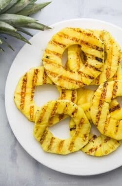 Overhead view of grilled pineapple slices on plate