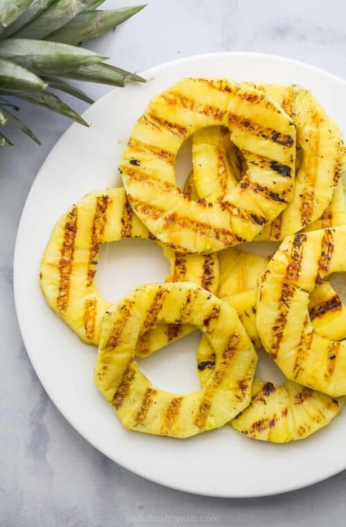 Overhead view of grilled pineapple slices on plate