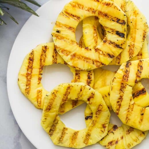 Overhead view of grilled pineapple slices on plate