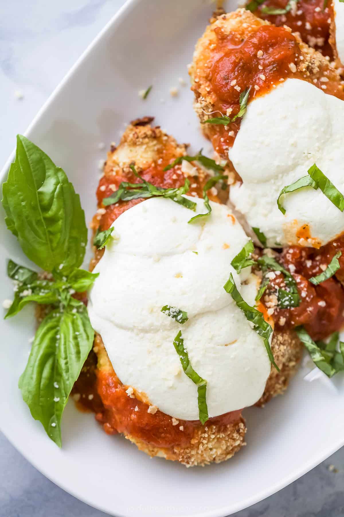 Close-up of healthy baked chicken parmesan with melty cheese. 