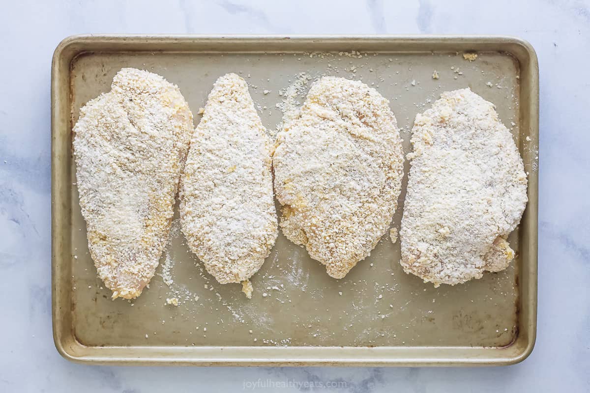Breaded chicken on the baking sheet.