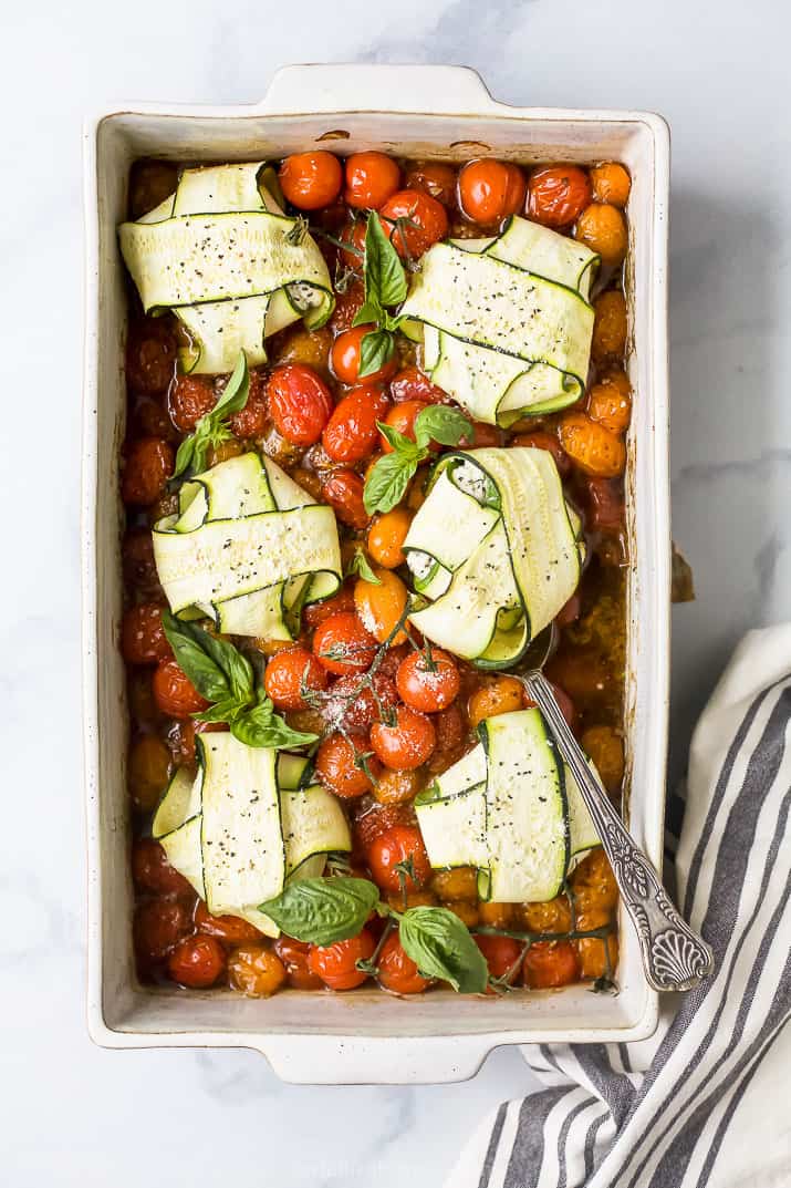 overhead photo of cheese zucchini ravioli in roasted tomato sauce with a spoon in a baking dish