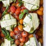 overhead photo of cheese zucchini ravioli in roasted tomato sauce with a spoon in a baking dish