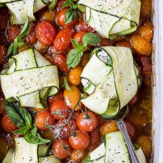 overhead photo of cheese zucchini ravioli in roasted tomato sauce with a spoon in a baking dish