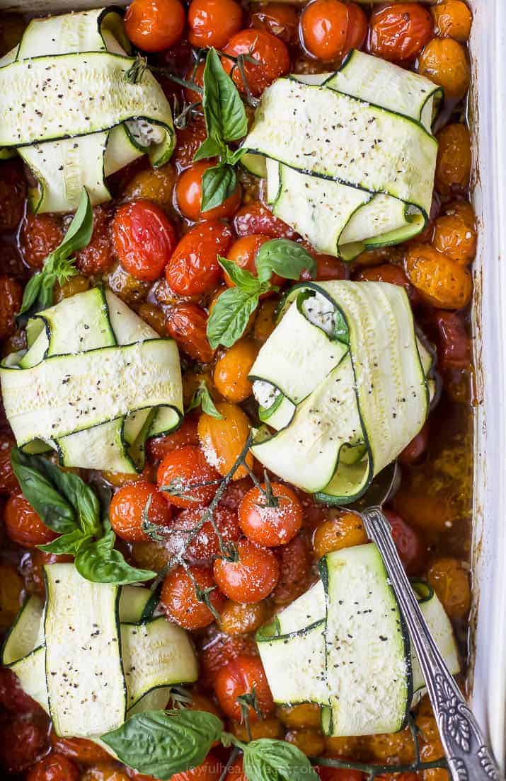 overhead photo of cheese zucchini ravioli in roasted tomato sauce with a spoon in a baking dish