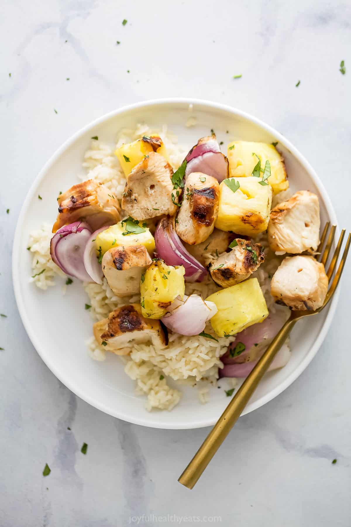Overhead view of grilled pineapple and chicken served on plate with rice