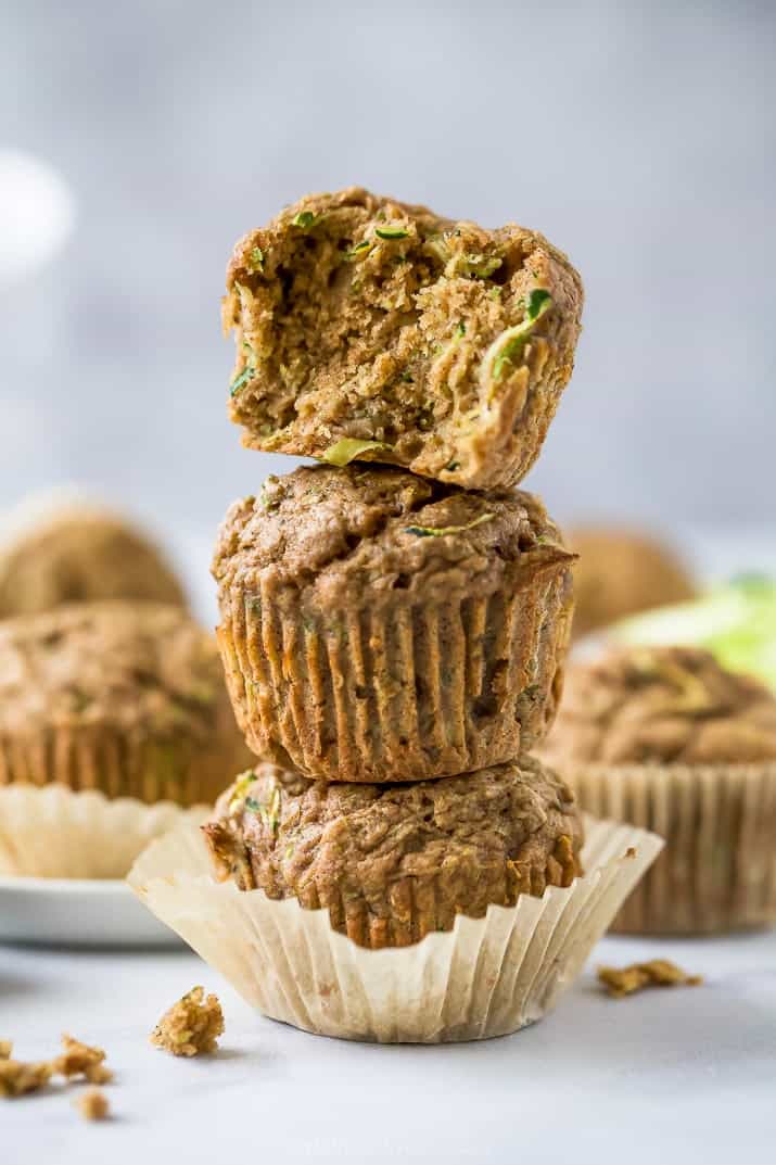 close up photo of moist healthy zucchini muffins stacked on top of each other