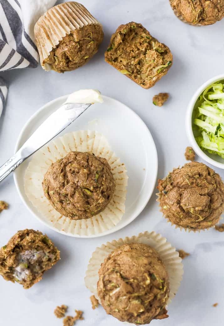 easy moist healthy zucchini muffins scattered all over a board