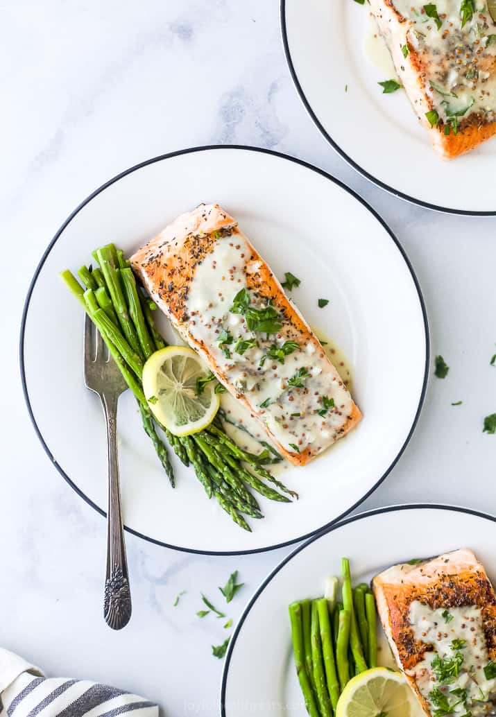 pan seared salmon drizzled with creamy dijon sauce on a plate