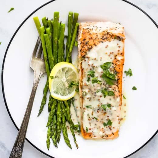 pan seared salmon drizzled with creamy dijon sauce on a plate