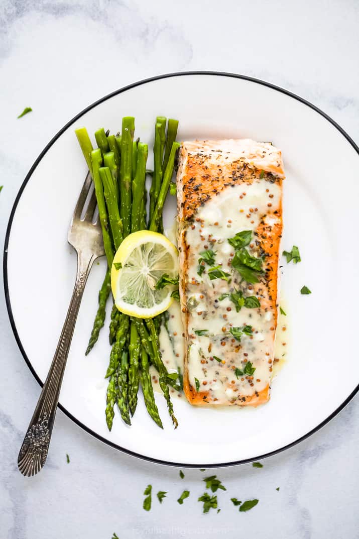pan seared salmon drizzled with creamy dijon sauce on a plate