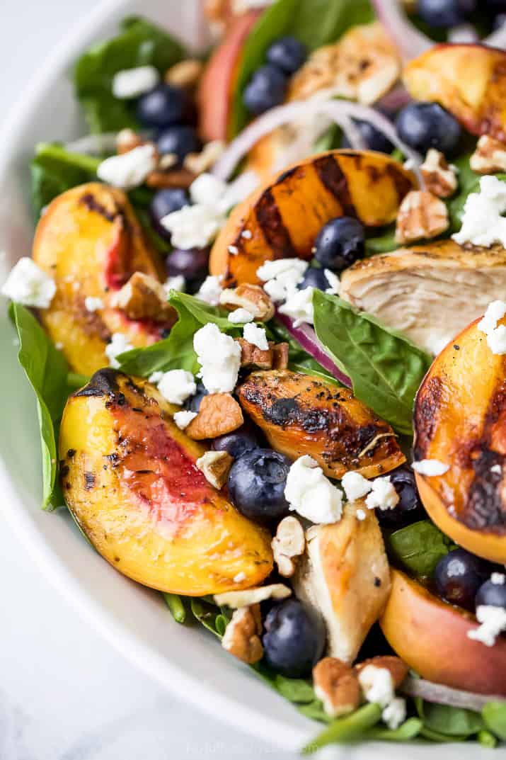 close up photo of grilled peach chicken salad in a bowl