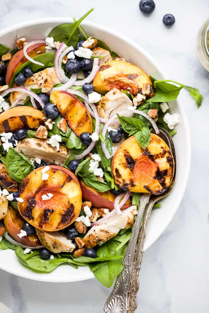 bowl filled with grilled peach chicken salad in a spoon in it