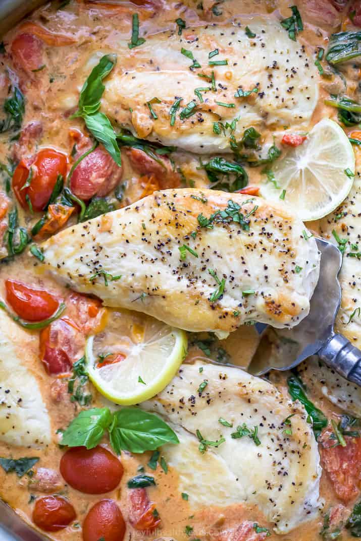 closeup photo of easy 30 minute creamy tuscan chicken in a pan with a spatula scooping