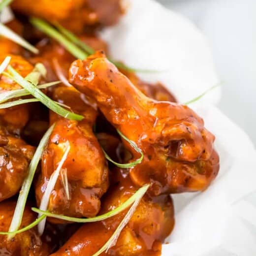 close up side photo of baked sweet and spicy bbq chicken wings in a basket