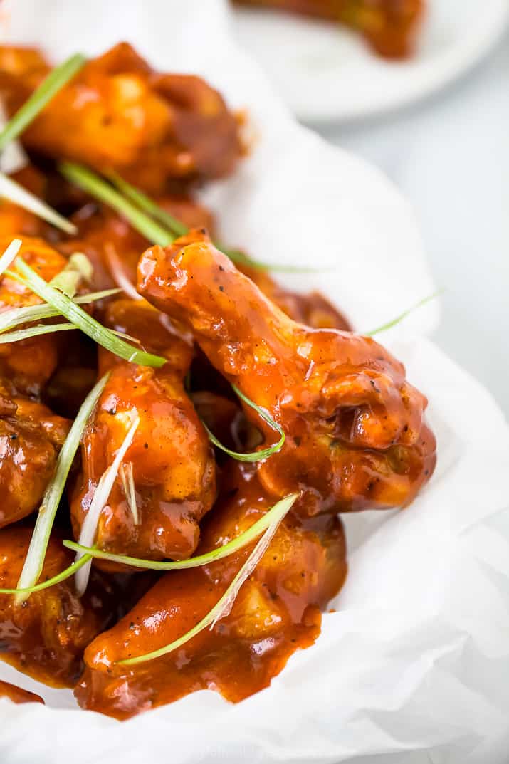 close up side photo of baked sweet and spicy bbq chicken wings in a basket