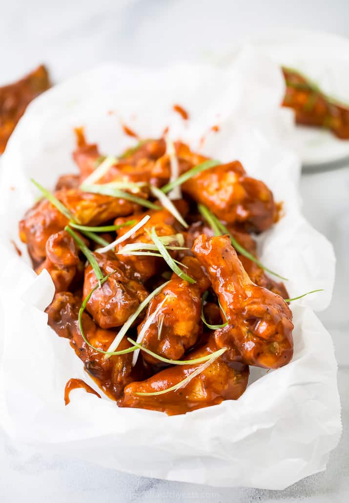 side photo of a basket full of baked sweet and spicy bbq chicken wings