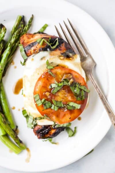 easy grilled balsamic caprese chicken on a plate with asparagus