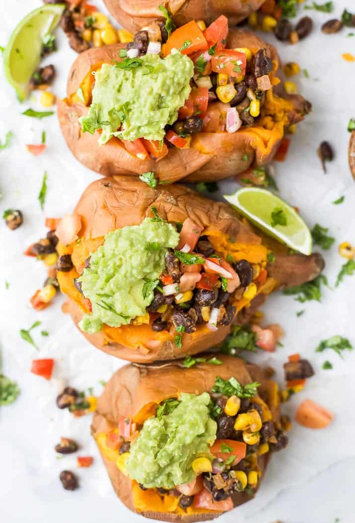 overhead photo of easy vegan black bean stuffed sweet potatoes with guacamole on top